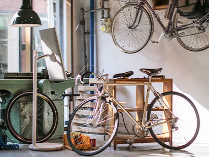 StanbyME staat midden in een fietsenwinkel. Hij staat naar achteren gericht.
