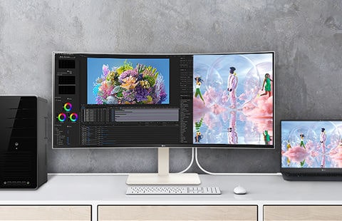 Er staat een UltraWide-monitor op het bureau en scherm is in tweeën gesplitst. Aan de linkerzijde wordt werk uitgevoerd op de desktop en aan de rechterzijde wordt hetzelfde werk uitgevoerd op een laptop.