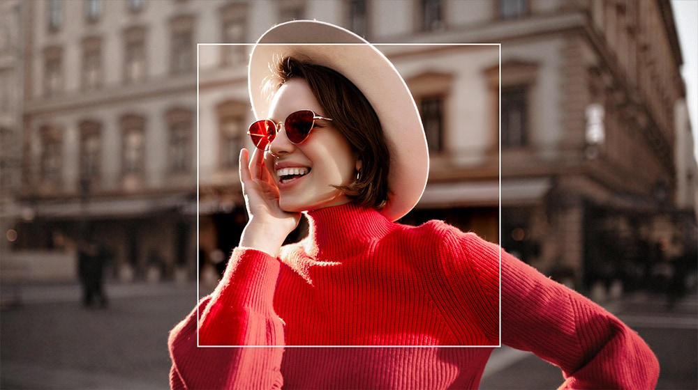 Imagen de una mujer en una ciudad. Encima de la mujer se aplica una superposición cuadrada que representa el AI Upscaling y la enfoca con detalle sobre un fondo artísticamente difuminado.