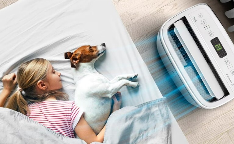 Una niña y su perro disfrutando del Aire Acondicionado Portátil LG