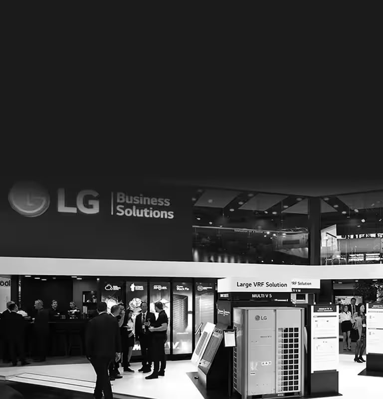 A black and white photo showing people gathered at the LG Business Solution exhibition, with the Large VRF Solution in the front right