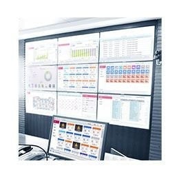 A series of screens displaying charts and diagrams are projected on a larger retangular screen while a computer monitor is placed at the front. 