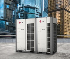 Two LG MULTI V i units stand side by side on a rooftop, front-facing view, against a backdrop of towering skyscrapers cloaked in the glass.	