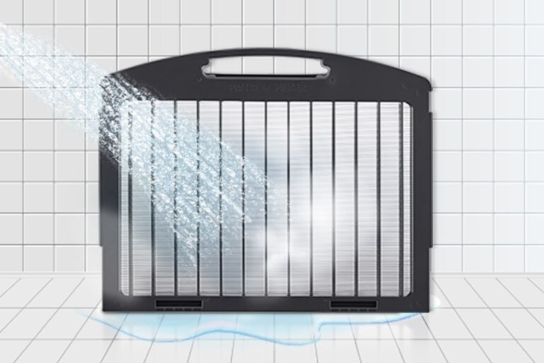 A rectangular, semi-permanent filter with a black outer frame and white center is being washed with water.