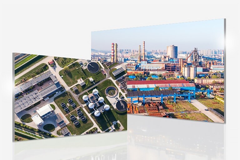 Aerial view showcases a sewage plant with a green area to the left, and slightly overlapping, an industrial site to the right.