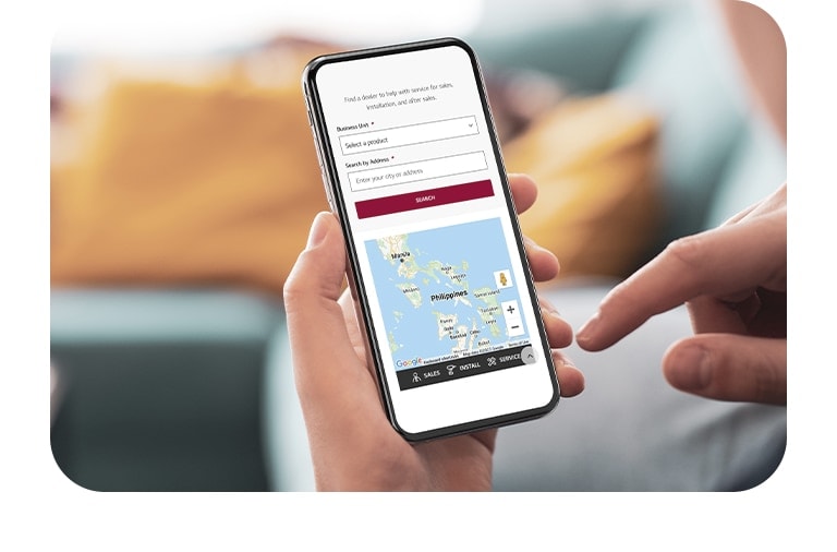 A man is viewing the 'Find the Dealer' page on lg.com on his cell phone.