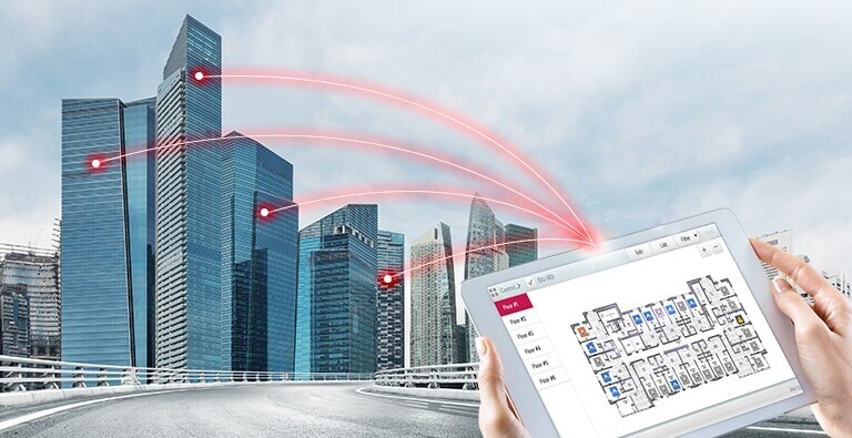 A person holds a tablet displaying a control solution. Four red lines extend from the tablet, connecting to buildings on the left.