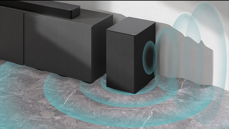 A sound bar is placed on the cabinet. Beside a wireless subwoofer placed on the floor. Blue sound graphics are coming out from the subwoofer.