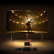 Uma Zero Connect Box em frente a um LG SIGNATURE OLED M4, com um sinal Wi-Fi vermelho e um feixe vermelho a emitir em direção à TV. A TV mostra uma bailarina a dançar a solo no palco.