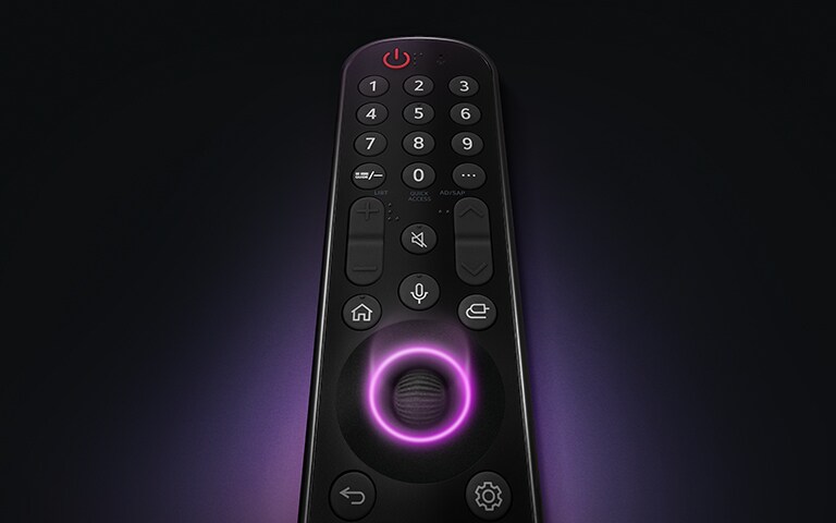 An LG Magic Remote with the middle circular button, as neon purple light emanates around the button to highlight them. A soft purple glow surrounds the remote on a black background.