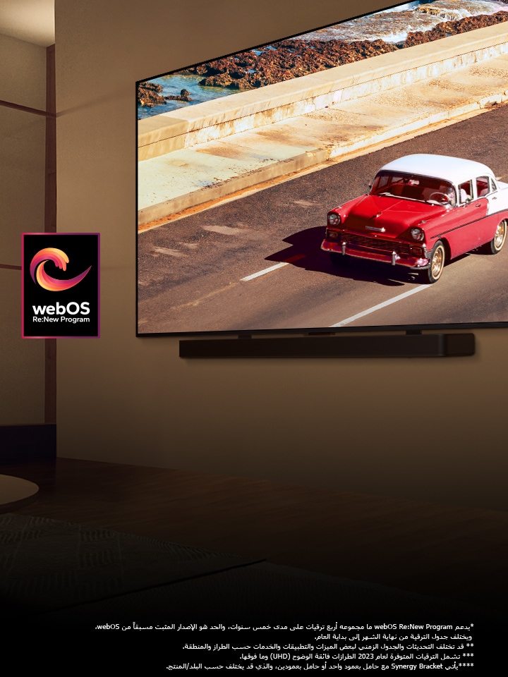 تلفزيون LG QNED TV ومكبر الصوت Soundbar مثبتان على حائط في غرفة مضاءة بإضاءة هادئة. على التلفزيون، تُعرض سيارة حمراء على الطريق. ويظهر شعار "webOS Re:New Program" في الصورة. وينص إخلاء المسؤولية على ما يلي: "يدعم webOS Re:New Program ما مجموعه أربع ترقيات على مدى خمس سنوات، والحد هو الإصدار المثبت مسبقًا من webOS، ويختلف جدول الترقية من نهاية الشهر إلى بداية العام." "قد تختلف التحديثات والجدول الزمني لبعض الميزات والتطبيقات والخدمات حسب الطراز والمنطقة." "يأتي Synergy Bracket مع حامل بعمود واحد أو حامل بعمودين، والذي قد يختلف حسب البلد/المنتج."