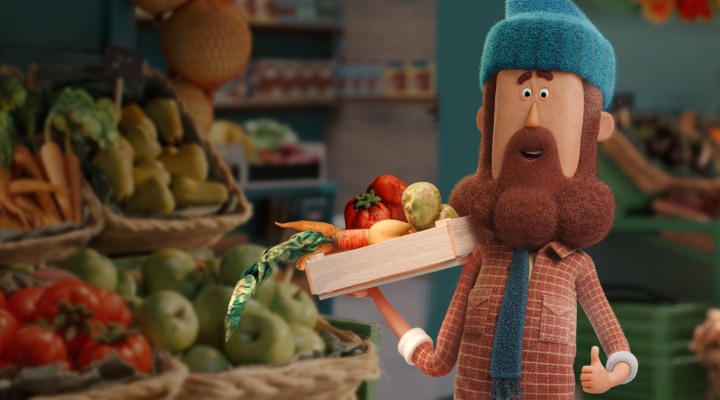 A man holding plates of misshapen and unattractive fruits and vegetables