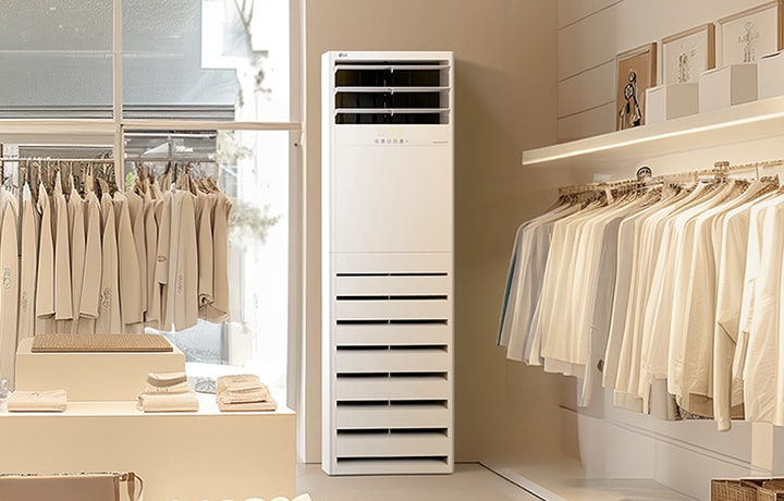 The LG Floor Standing Unit is placed in a minimalist clothing store with neutral-colored neatly displayed on racks and shelves. 