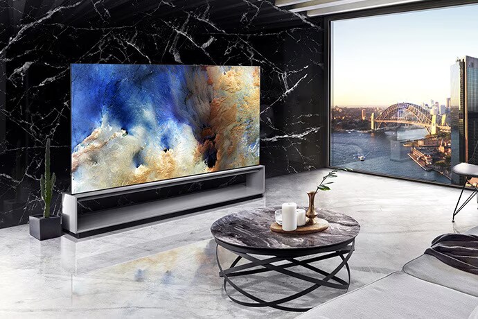 LG SIGNATURE OLED 8K TV placerad i mitten av ett vardagsrum dekorerat med spansk Nero Marquina-marmor, med staden som bakgrund.