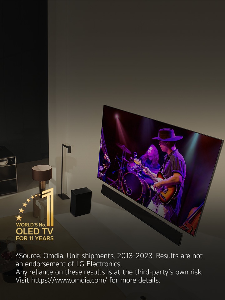 An overhead perspective of a man and woman watching a concert on a large OLED TV in a modern apartment. The "World's number 1 OLED TV for 11 Years" emblem is in the image. A disclaimer reads: "Source: Omdia. Unit shipments, 2013 to 2023. Results are not an endorsement of LG Electronics. Any reliance on these results is at the third party’s own risk. Visit https://www.omdia.com/ for more details."