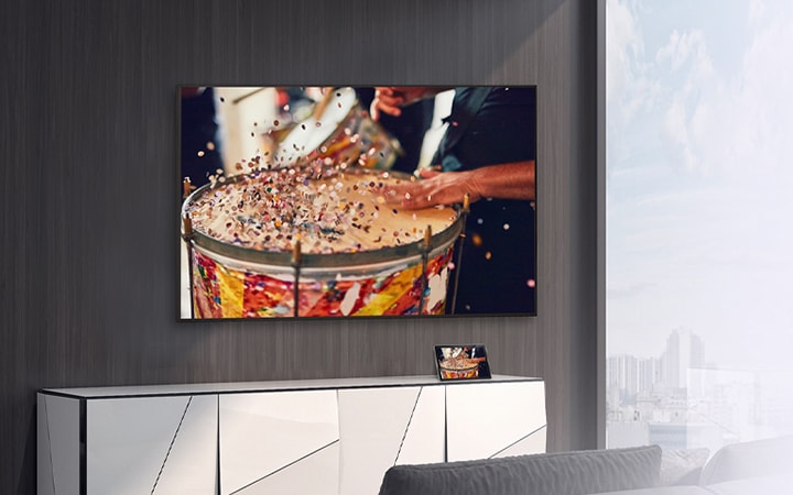 In the room, a wall-mounted TV is set up, with a tablet placed on the shelf. The tablet’s content is mirrored and displayed on the TV.	