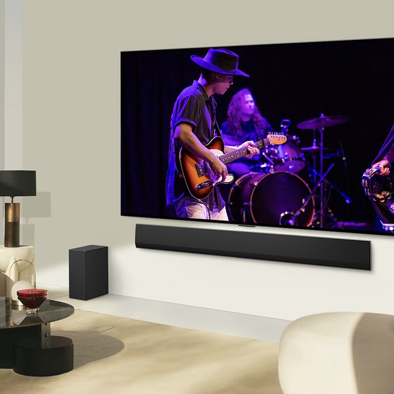 La LG Soundbar et la LG TV s’accordent dans une pièce de vie moderne, diffusant un concert.