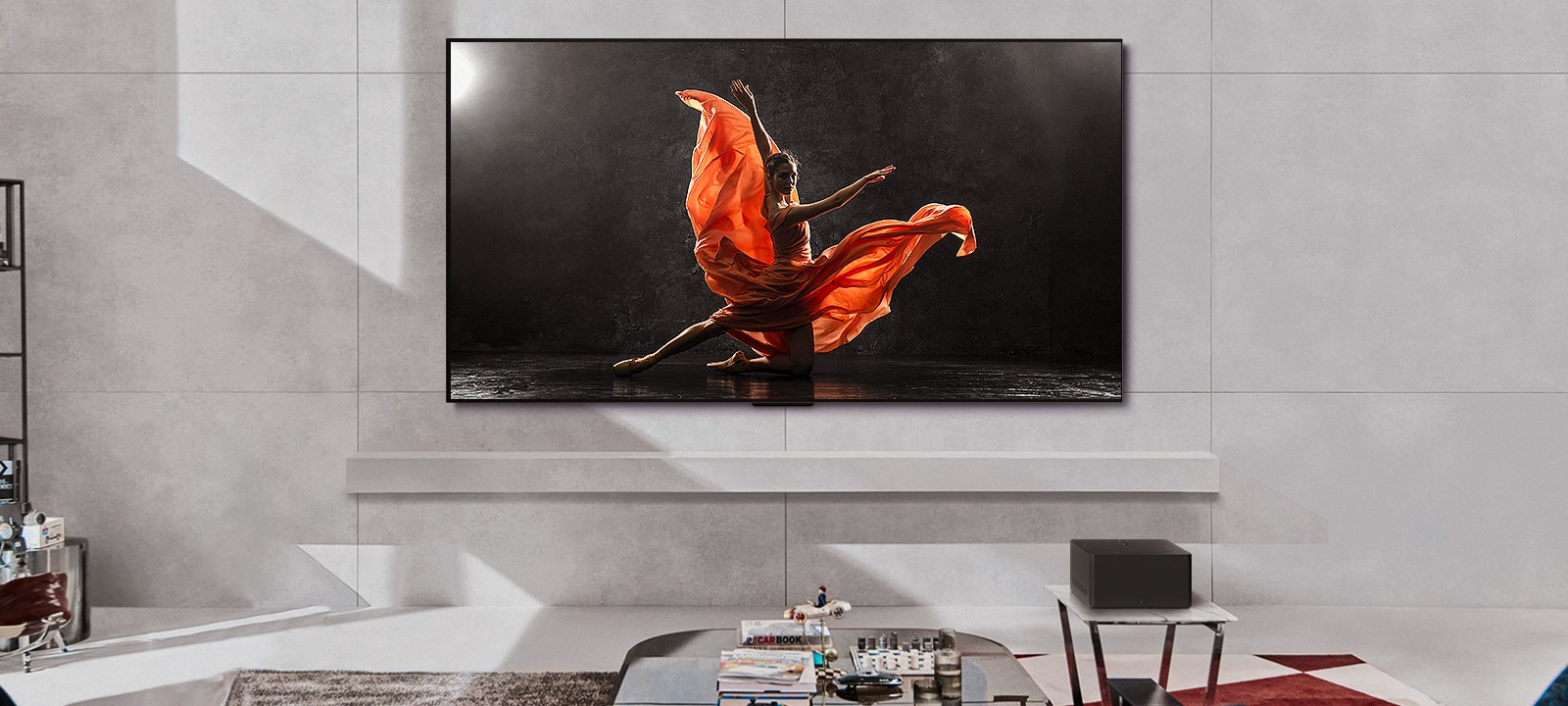 LG SIGNATURE OLED M4 and LG Soundbar in a modern living space in daytime. The screen image of a dancer on a dark stage is displayed with the ideal brightness levels.