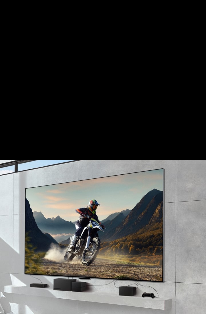 LG SIGNATURE OLED M4 mounted on a wall showing a man riding a motorbike on a dirt track, and devices connected to the TV by messy wires underneath. The devices fade and the shot zooms out to reveal a bright, modern living room and a Zero Connect Box on a table with devices neatly organised underneath. The image darkens briefly and highlights the Zero Connect Box and devices. A red Wi-Fi signal appears and a red beam emits towards the TV and red circles eminate.