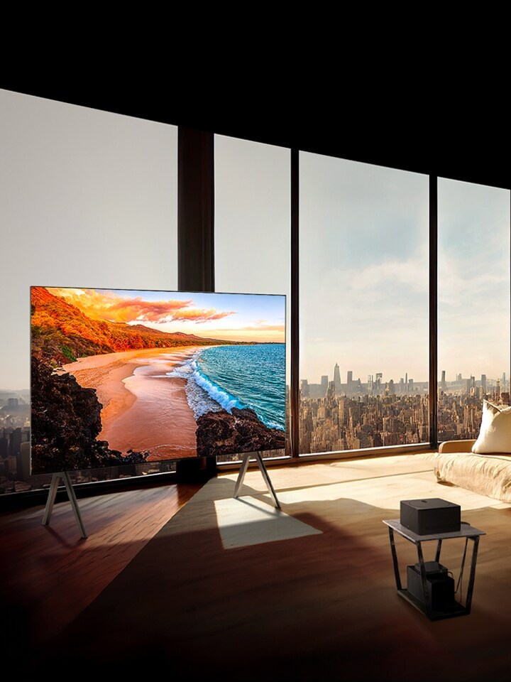 LG SIGNATURE OLED M4 on a stand in front of floor-to-ceiling windows in a sunny, modern apartment.