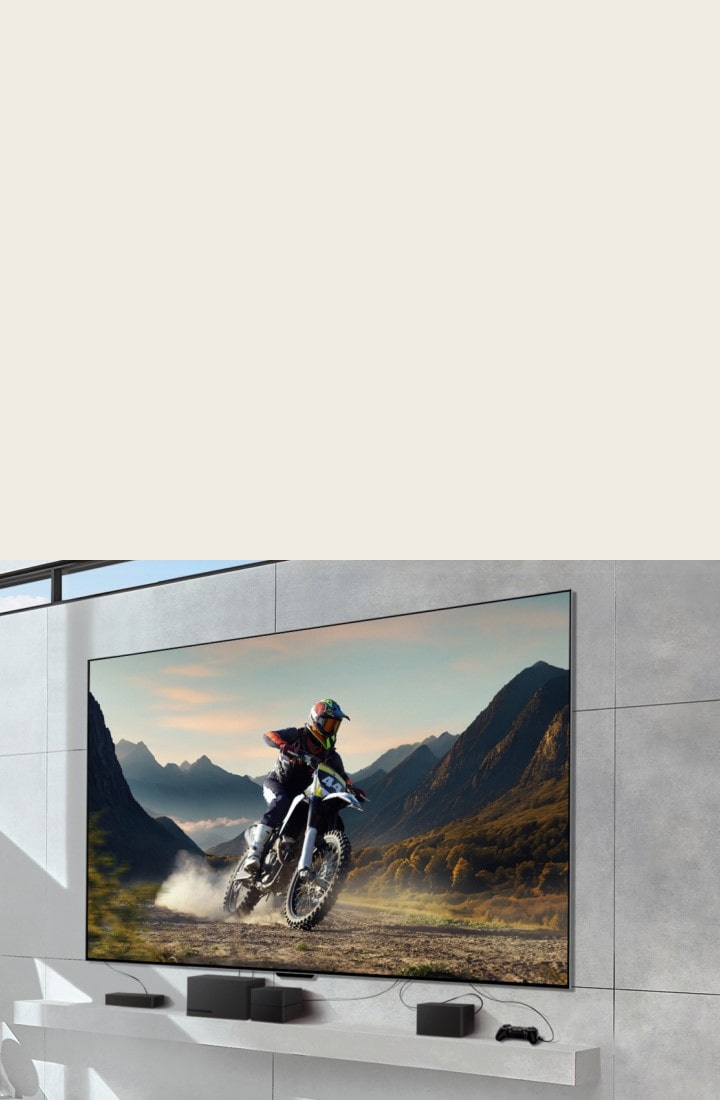LG OLED evo M4 mounted on a wall showing a man riding a motorbike on a dirt track, and devices connected to the TV by messy wires underneath. The devices fade and the shot zooms out to reveal a bright, modern living room and a Zero Connect Box on a table with devices neatly organised underneath. The image darkens briefly and highlights the Zero Connect Box and devices. A red Wi-Fi signal appears and a red beam emits towards the TV and red circles eminate.