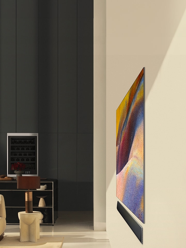 A side view of the LG OLED G4 displaying an elegant abstract artwork and LG Soundbar flat against the wall in a modern living space.	