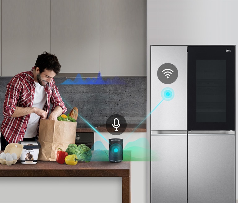 ชายหนุ่มในห้องครัวหยิบผักจากถุงกระดาษวางบนเคาน์เตอร์ข้างตู้เย็น LG ที่เชื่อมต่อ Wi-Fi และผู้ช่วยเสียง