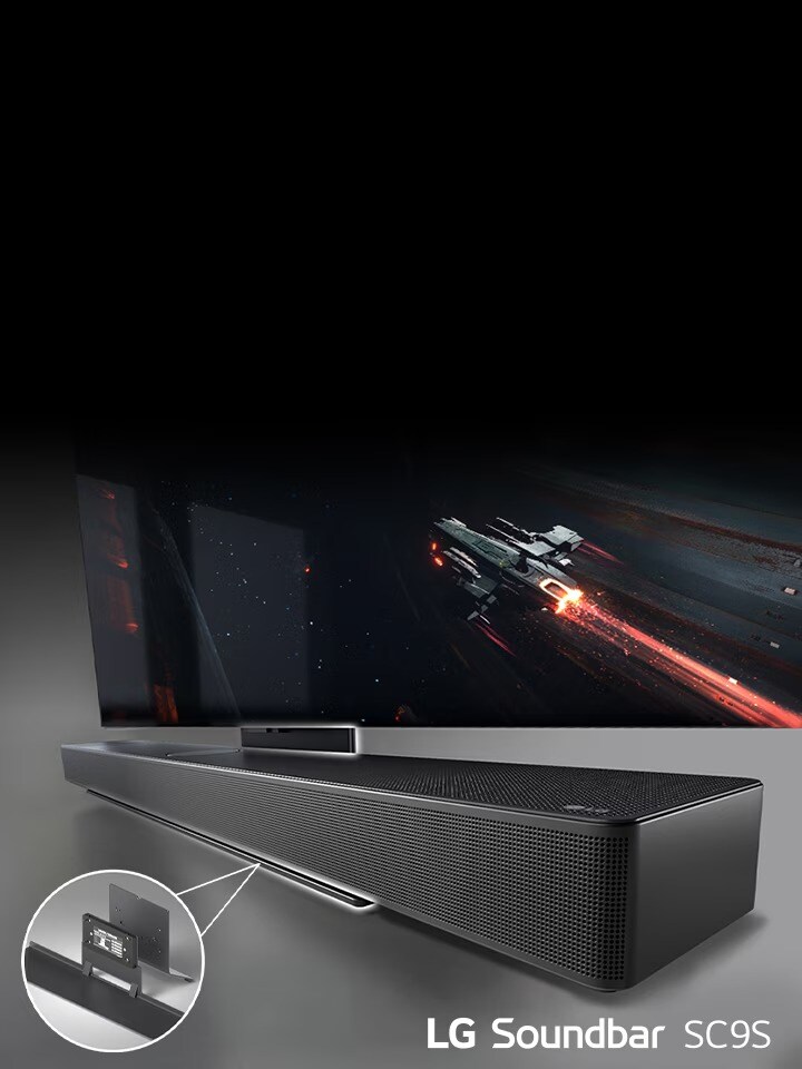 TV ve LG Soundbar SC9S beyaz bir duvara asılıdır. Aşağıda, zemine siyah bir kablosuz subwoofer yerleştirilmiştir. Soldaki pencerenin ötesinde mavi gökyüzünün göründüğü şehir manzarası vardır.