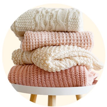 Knits are stacked on the table.