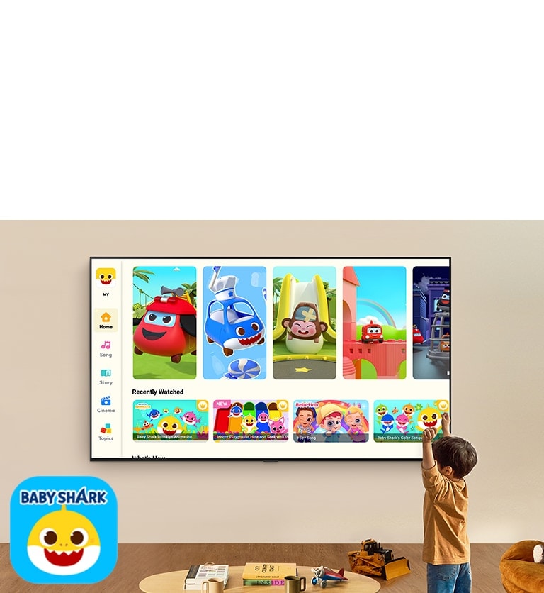 小男孩在客廳空間中看著壁掛 LG TV 上的 Pinkfong，旁有兒童玩具。