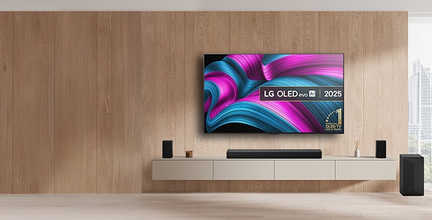 LG oled tv on the wall with a soundbar and speakers and subwoofer underneath with promo message to get a free soundbar when buying pre-set bundles