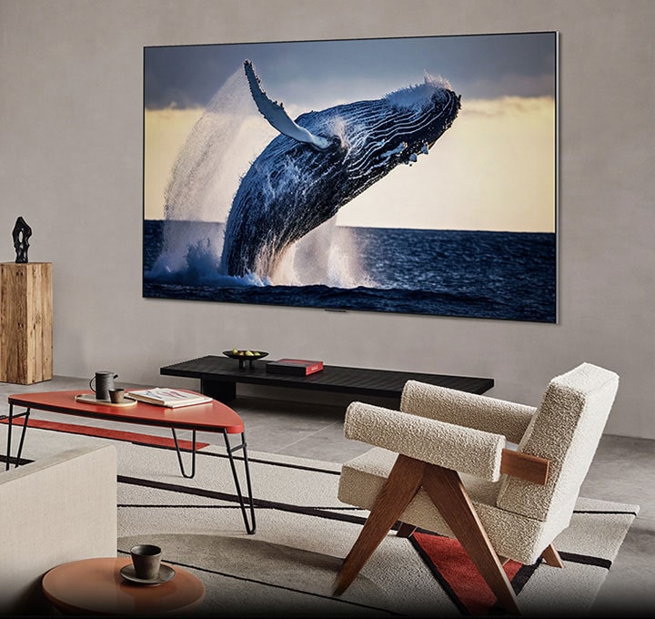LG 4K TV mounted on the wall, screen showing a whale leaping out of the water in high quality 4k ultra hd resolution in a living room.