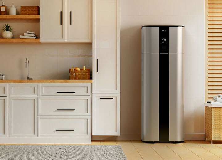 An installer in front of the LG Therma V heat pump placed on the exterior of a house is facing the couple and explaining the heating solution.