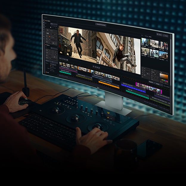 A man working on video editing using video editing software on a monitor.