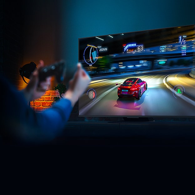 Hands holding a game controller in front of a TV with a car racing game on the screen. VRR, variable refresh rate logo is visible.