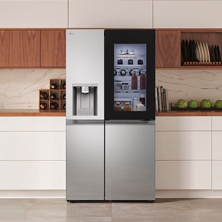 LG Side-by-Side Refrigerator GSXE81PYBD in a stainless steel finish, featuring InstaView™ Door-in-Door® and a dispenser, seamlessly integrated into a modern kitchen with white and wood cabinets.