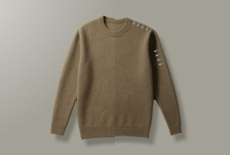 A video showing a brown sweater not shrunk after drying and a man pleased with the fabric texture of clothes.