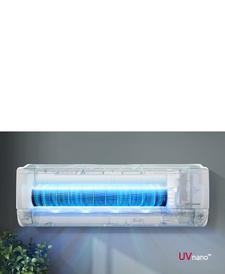 Wall-mounted LG air conditioner with glowing UVnano technology, emitting blue light, above green leafy plants.