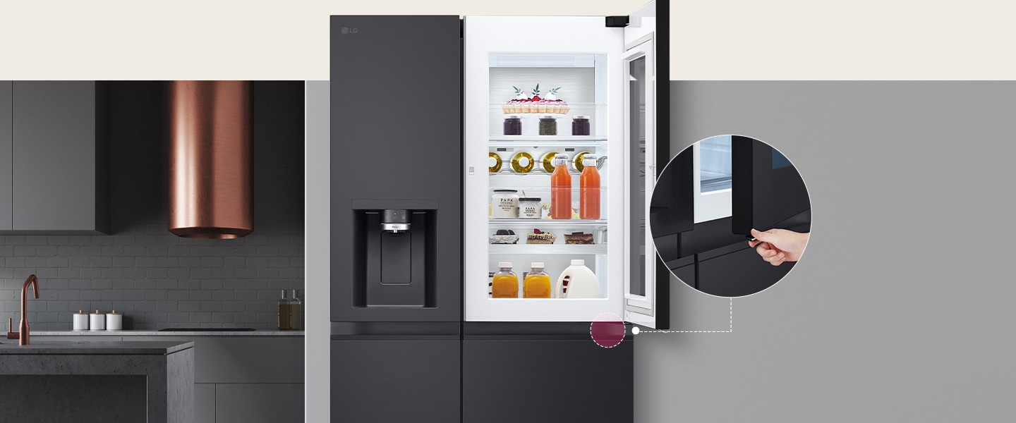 Modern kitchen with grey cabinetry and copper hood, featuring an open LG fridge with drinks and desserts.