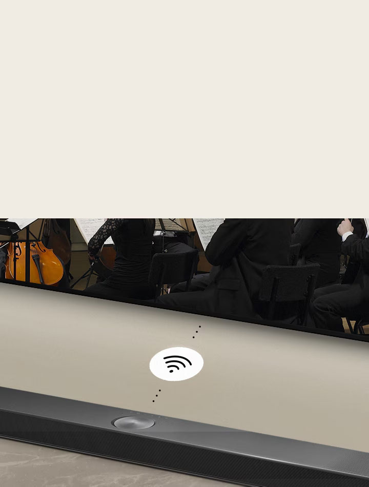Un dettaglio della soundbar installata a parete sotto al TV LG. Fra di essi c'è un simbolo di connettività che indica la funzione WOWCAST senza fili.