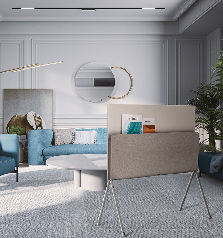 LG OLED Posé is seen from behind in a blue coastal-themed living room with magazines placed on the media shelf.	