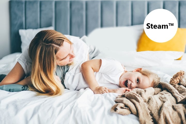 The child and mother are lying on the bed.