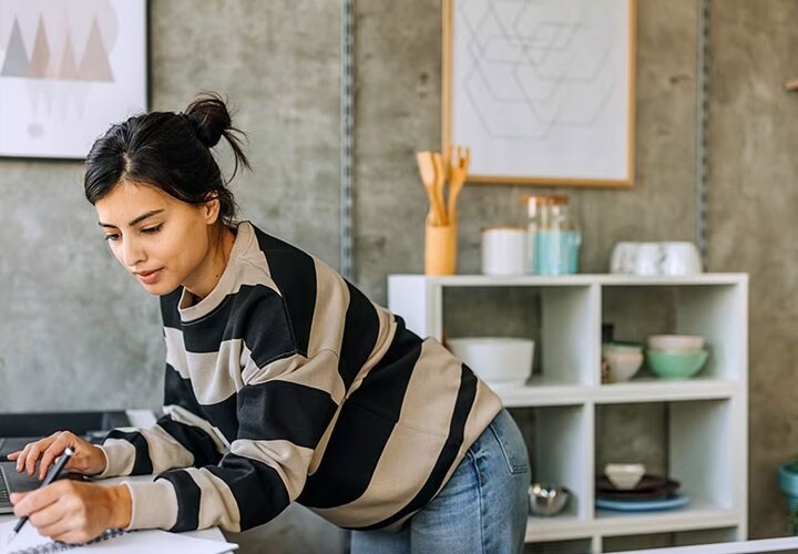 A woman measures her kitchen to find the right refrigerator sizes