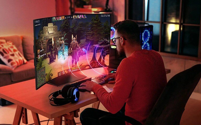 A gamer fully immersed in a vibrant scene on an LG curved monitor, demonstrating how the ultra-wide screen enhances the gaming experience.