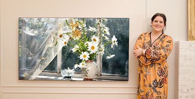 Image of a woman with a flower arrangement.	