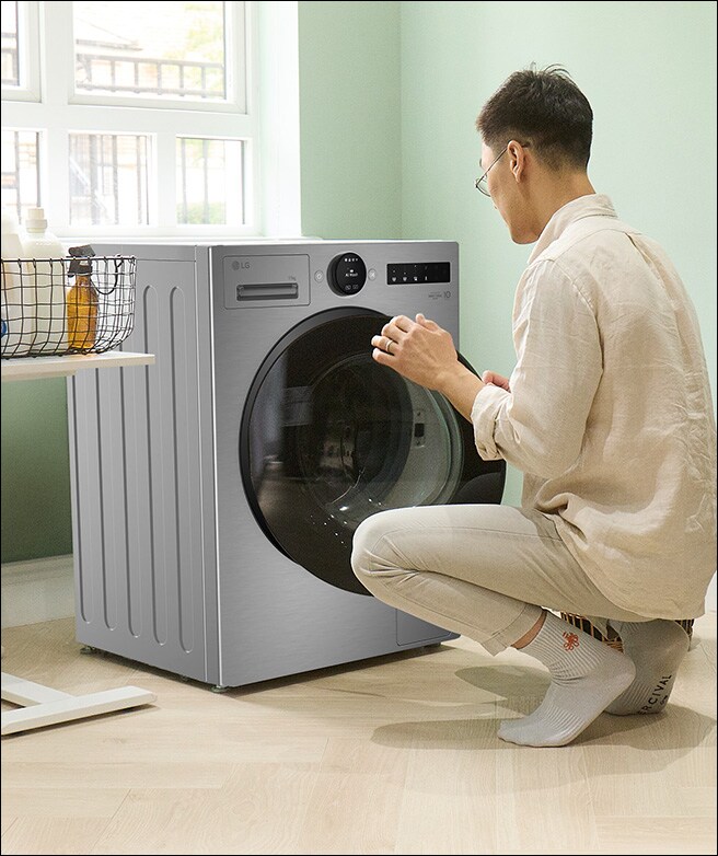 Man loading clothes into a washing machine.