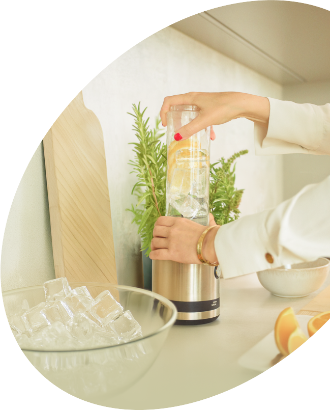 Woman blending ice and ingredients.