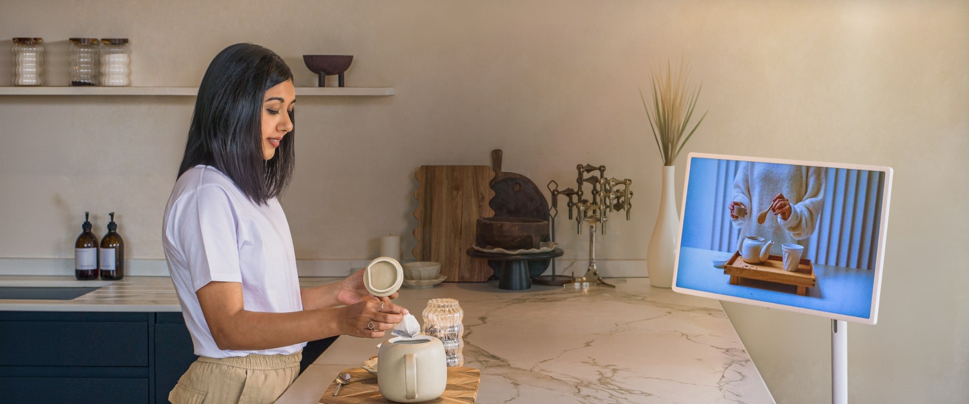 Lisa Mistry is brewing tea at the breakfast bar while watching a video on how to brew tea on her LG StandbyME.