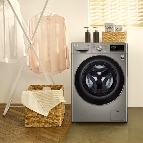 Clean, freshly washed shirts are hanging on a drying rack next to the LG washing machine