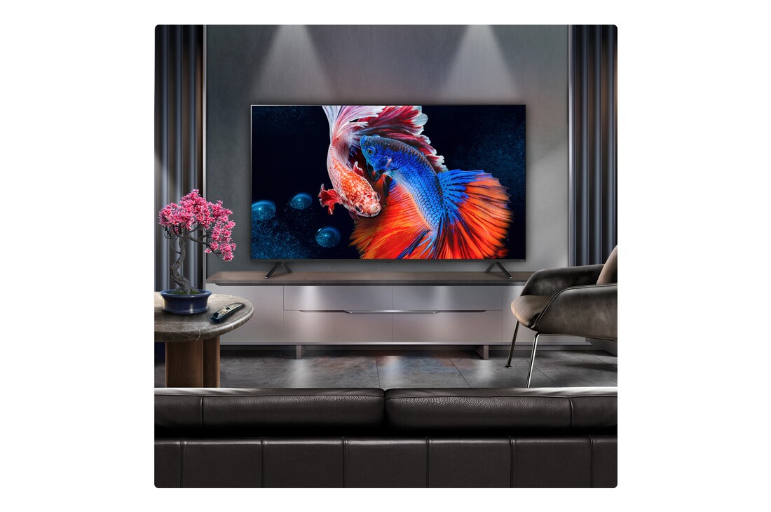 A family sits on a couch facing a LG QNED TV sitting above a TV stand with a little girl pointing to a screen depicting two dolphins. The title talks about how you can enjoy high resolution on a massive screen.